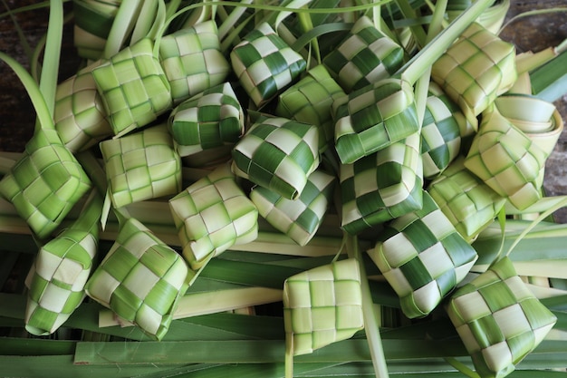 Ketupat (Reisknödel). Ketupat ist eine natürliche Reishülle aus jungen Kokosblättern