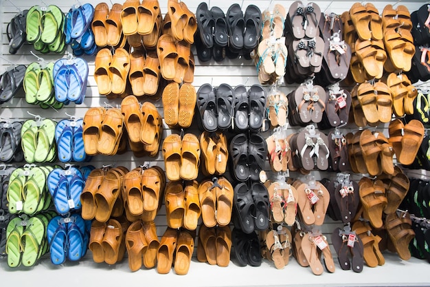 Key West, EUA-26 de dezembro de 2015: Sandálias de borracha na vitrine da loja, compras. Variedade de sapatos masculinos e femininos de cores diferentes. Piscina ou toboáguas de praia. Conceito de férias de verão. Lazer
