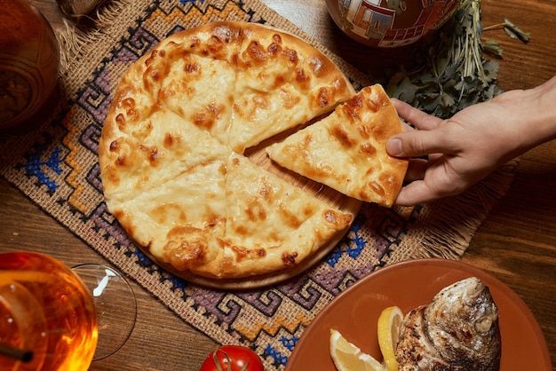 Khachapuri auf der weiblichen Hand des Tisches Draufsicht