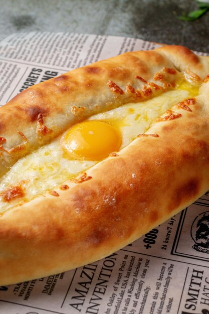 Khachapuri em Adjarian com ovo. Tortilhas tradicionais com ovos da culinária georgiana. Comida oriental. Serviço de restaurante.