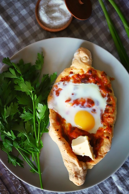 Khachapuri con huevo y hierbas en un plato