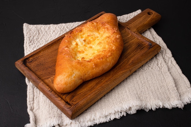 Khachapuri Khachapuri auf schwarzem Hintergrund Georgische Küche