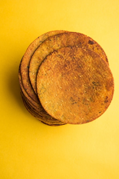 Khakhra o Khakra es una galleta fina que es un alimento popular para el desayuno Jain, Gujarati y Rajasthani. Servido con té caliente y salsa de tomate. Sobre fondo de colores o madera