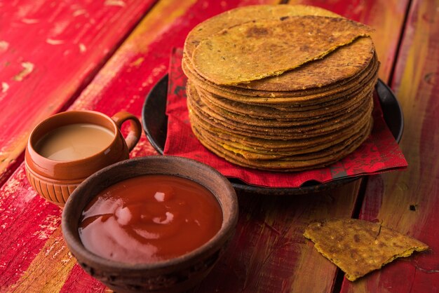 Khakhra oder Khakra ist ein dünner Cracker und ist ein beliebtes Frühstücksessen der Jain, Gujarati und Rajasthani. Serviert mit heißem Tee und Tomatenketchup. Über buntem oder hölzernem Hintergrund