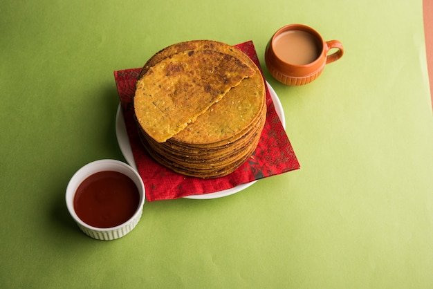 Khakhra oder Khakra ist ein dünner Cracker und ist ein beliebtes Frühstücksessen der Jain, Gujarati und Rajasthani. Serviert mit heißem Tee und Tomatenketchup. Über buntem oder hölzernem Hintergrund