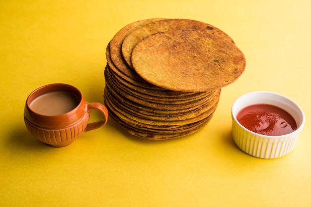 Khakhra oder Khakra ist ein dünner Cracker und ist ein beliebtes Frühstücksessen der Jain, Gujarati und Rajasthani. Serviert mit heißem Tee und Tomatenketchup. Über buntem oder hölzernem Hintergrund