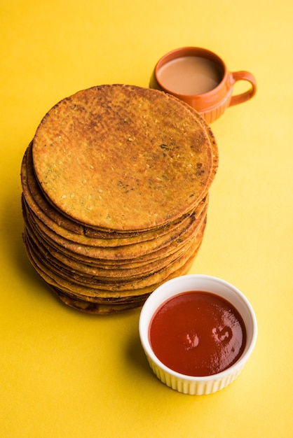 Khakhra oder Khakra ist ein dünner Cracker und ist ein beliebtes Frühstücksessen der Jain, Gujarati und Rajasthani. Serviert mit heißem Tee und Tomatenketchup. Über buntem oder hölzernem Hintergrund