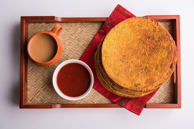 Khakhra oder Khakra ist ein dünner Cracker und ist ein beliebtes Frühstücksessen der Jain, Gujarati und Rajasthani. Serviert mit heißem Tee und Tomatenketchup. Über buntem oder hölzernem Hintergrund