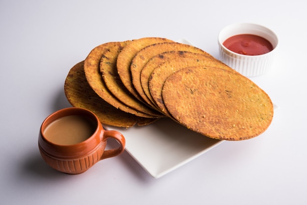 Khakhra ou Khakra é um biscoito fino é um alimento de café da manhã popular Jain, Gujarati e Rajasthani. Acompanha Chá Quente e Ketchup de Tomate. Sobre fundo colorido ou de madeira