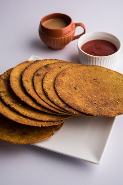 Khakhra ou Khakra é um biscoito fino é um alimento de café da manhã popular Jain, Gujarati e Rajasthani. Acompanha Chá Quente e Ketchup de Tomate. Sobre fundo colorido ou de madeira