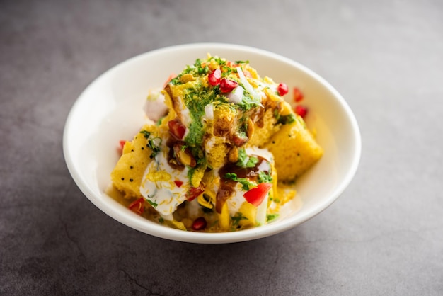 Foto khaman dhokla chaat es una receta de chaat de fusión muy simple y refrescante hecha con restos de dhokla