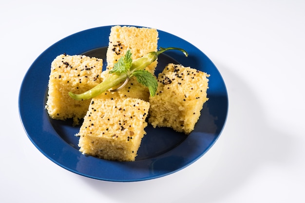 Khaman Dhokla ist ein Gemüsesnack oder Frühstücksartikel aus dem indischen Bundesstaat Gujarat. serviert mit gebratener grüner Chili