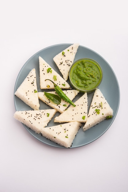 Khaman White Dhokla aus Reis oder Urad Dal ist ein beliebtes Frühstücks- oder Snackrezept aus Gujrat, Indien, serviert mit grünem Chutney und heißem Tee. Selektiver Fokus