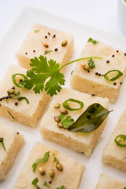 Khaman white Dhokla feito de arroz ou urad dal é um café da manhã popular ou receita de lanches de Gujarat, Índia, servido com chutney verde e chá quente. Foco seletivo