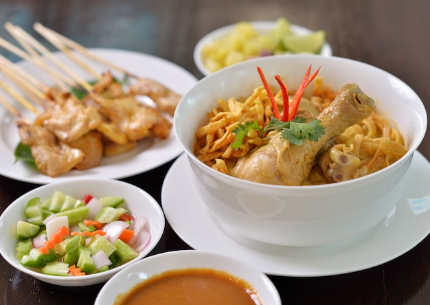 Khao Soi Chicken, plato de fideos del norte de Tailandia con sopa de pollo y coco al curry, que se muestra con fideos crujientes y otras verduras