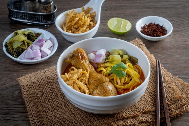 Khao Soi Kai fideos tailandeses Khao Soi pollo con condimentos servido en la mesa