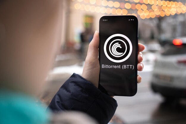 Kharkov Ukraine 2. Februar 2022 Bittorrent BTT Münzsymbol Handel mit Kryptowährung digitales und virtuelles Geld Mobile Banking Hand mit Smartphone-Bildschirm mit Krypto-Symbol Nahaufnahme