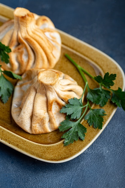 Khinkali, albóndigas georgianas, cocina tradicional georgiana. Khinkali en una vista lateral de placa.