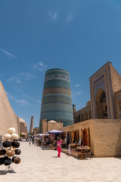 KHIVA UZBEKISTAN JUNHO 29 2023 Antiga KaltaMinor minarete na paisagem urbana em um dia ensolarado
