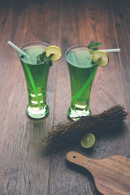 Khus Sharbat o Vetiver Drink servido en un vaso con una rodaja de limón y menta, enfoque selectivo