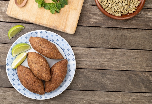 Kibbeh frito árabe tradicional sobre mesa de madera con espacio de copia. Bocadillo típico brasileño.