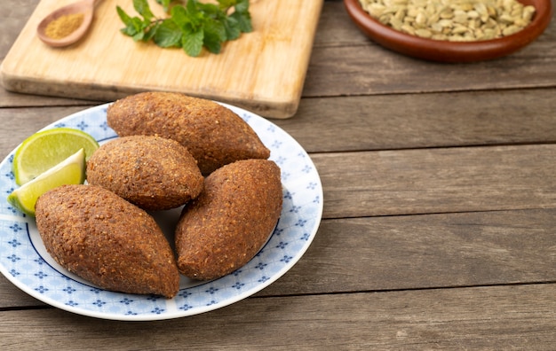 Kibbeh frito árabe tradicional sobre mesa de madera con espacio de copia. Bocadillo típico brasileño.