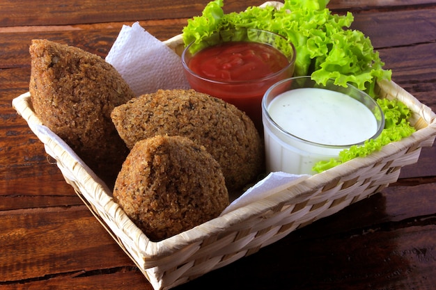 Kibbeh frito con salsa de tomate en una cesta