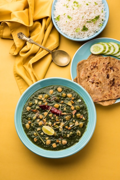 Kichererbsen-Spinat-Curry oder Chana Masala mit Palak serviert mit Reis und Fladenbrot oder Paratha, selektiver Fokus