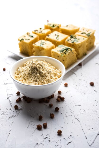 Kichererbsenmehl oder Besan-Pulver in einer Keramik- oder Holzschüssel zusammen mit Gujrati Dhokla Snack