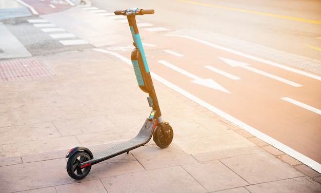 Kick scooter na calçada perto da ciclovia