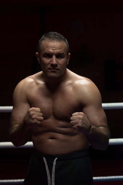 kickboxer profesional con las manos en posición de artes marciales entrenando para la pelea en el ring de entrenamiento