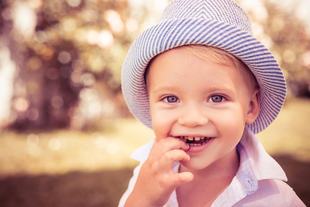 Kid Boy auf grünem Hintergrund Park in der Natur Wow-Look Portrait von erstaunten niedlichen kleinen Jungen mit lockigem Haar überrascht Vorschulkind Glückliche Kinder Emotionen lächelndes Gesicht