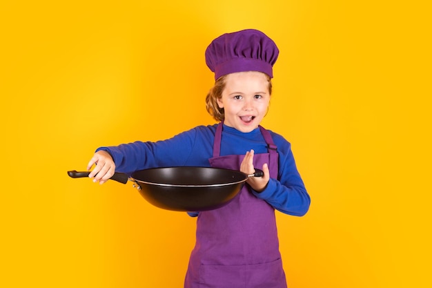 Kid Boy Chefkoch mit Kochpfanne Chefkind, das gesundes Essen zubereitet Studioporträt des Kindes mit Kochmützen
