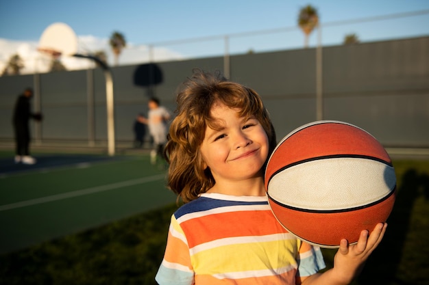 Kid boy concentrado en jugar baloncesto alegre y agradable