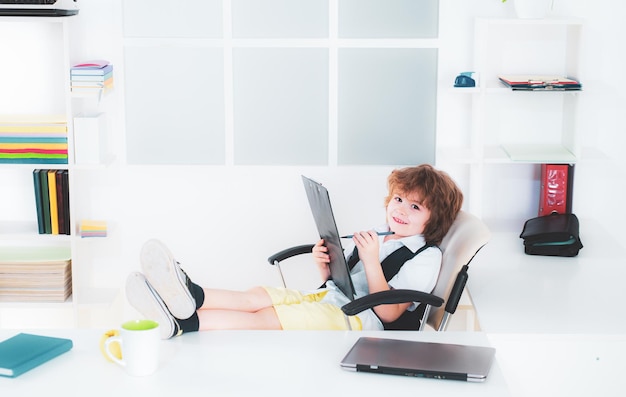 Kid boy empresario vendedor trabajando en la computadora en la oficina pequeño niño programador negocio