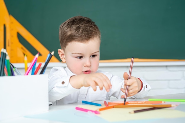 Kid boy escribiendo en el aula Colegial estudiando la tarea durante su lección en casa