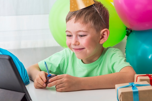 Kid Boy feiert Geburtstag online mit Freund oder Großeltern auf Videoanruf
