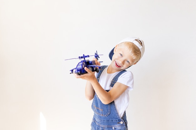 Kid Boy in Blue Jeans spielt mit einem Hubschrauber