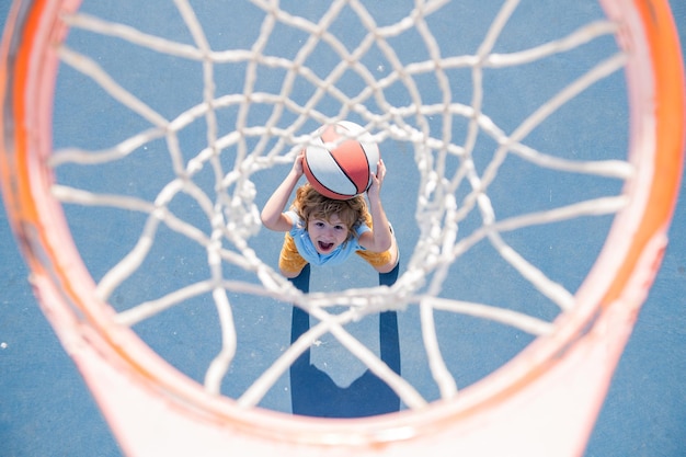 Kid boy jugando baloncesto con pelota de baloncesto