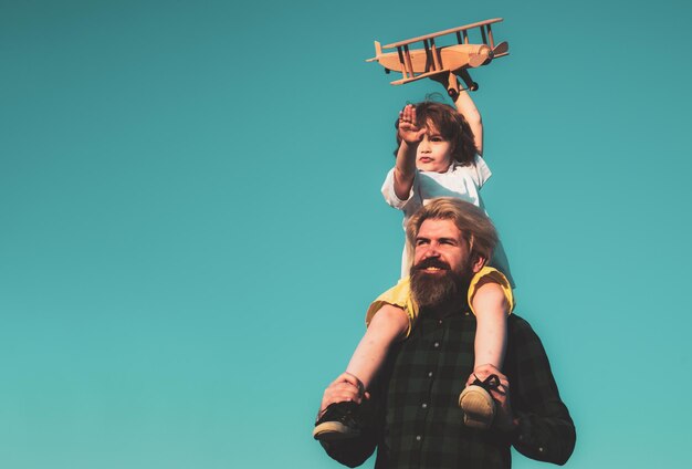 Kid Boy Pilot Vater und Sohn spielen mit Holzflugzeug