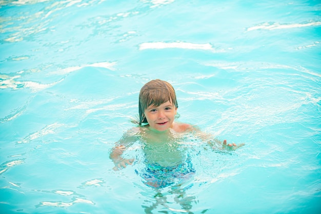 Kid Boy spielt und schwimmt im blauen Meer im Sommer Blue Ocean mit Wawes Kinderjunge schwimmt im Meer