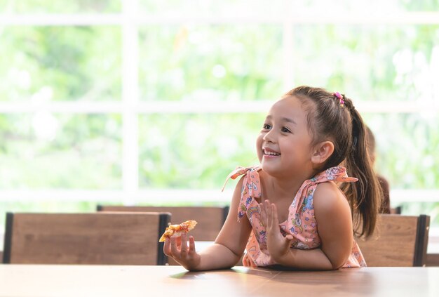 Kid está comendo pizza de entrega em sala de aula