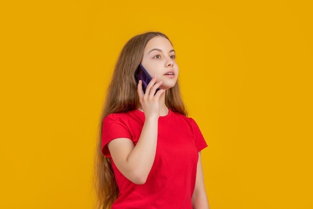 Kid hablar en el teléfono inteligente sobre fondo amarillo