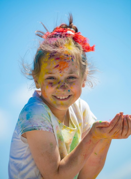 Kid Holi Festival gemaltes Gesicht des lustigen Kindes kleiner Junge spielt mit Farben