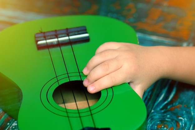 Kid mano sosteniendo un pequeño ukelele