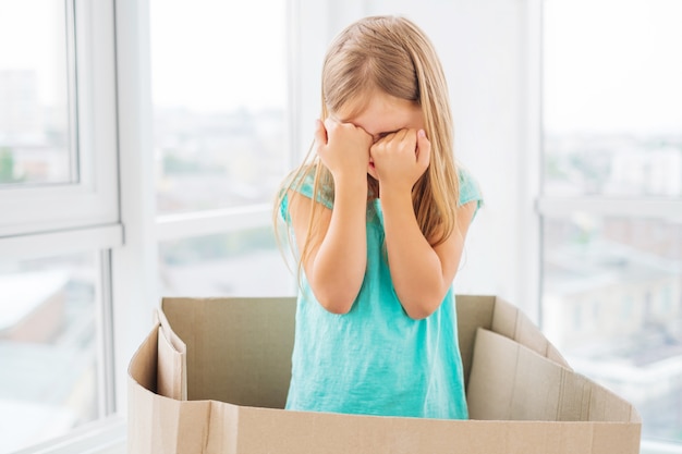 Kid niña cubriéndose la cara con los puños en la caja