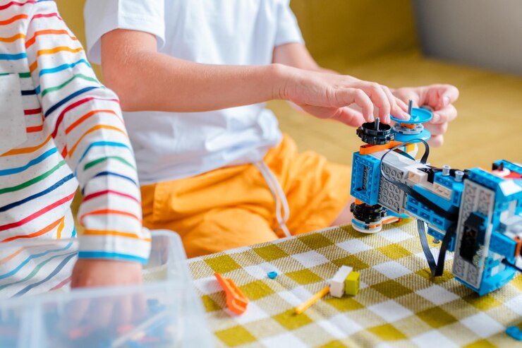 Foto kid recoge el robot de los detalles de plástico y programa en la robótica de la tableta