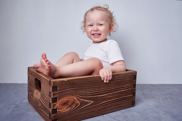 Foto kid está sentado en una vieja caja de madera para una sesión de recién nacido