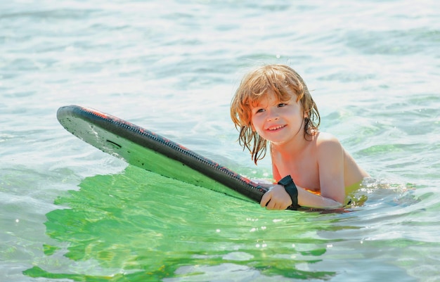 Kid serfer atrapar la ola deporte extremo actividad niño feliz jugando en el agua de mar