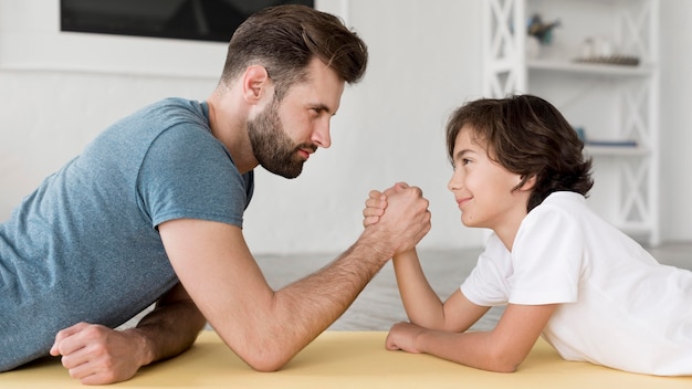 Foto kid y su padre haciendo deporte en casa